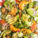 Slices of nectarines, avocados, peppers, onions over arugula, sprinkled with pistachios, cinnamon, lime salt and pepper.