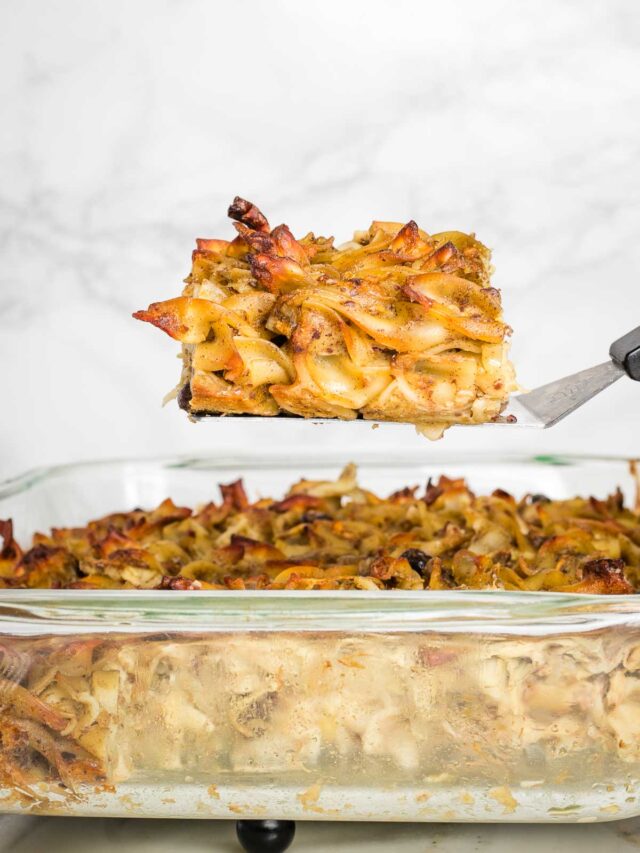 Piece of noodle kugel pulled up on a spatula above the entire casserole.