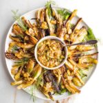 Braised fennel wedges on a plate with sauce in the middle.