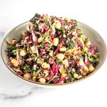 Colorful chopped salad with kale, radicchio, purple daikon, chickpeas and walnuts.