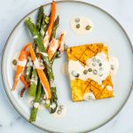 Tofu steak, carrot and asparagus drizzled with tahini lemon caper sauce.