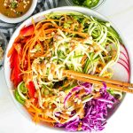 Zucchini noodles, carrot ribbons, red peppers, cabbage and radish with peanut sauce drizzled over and peanuts, scallions and jalapenos sprinkled on top.