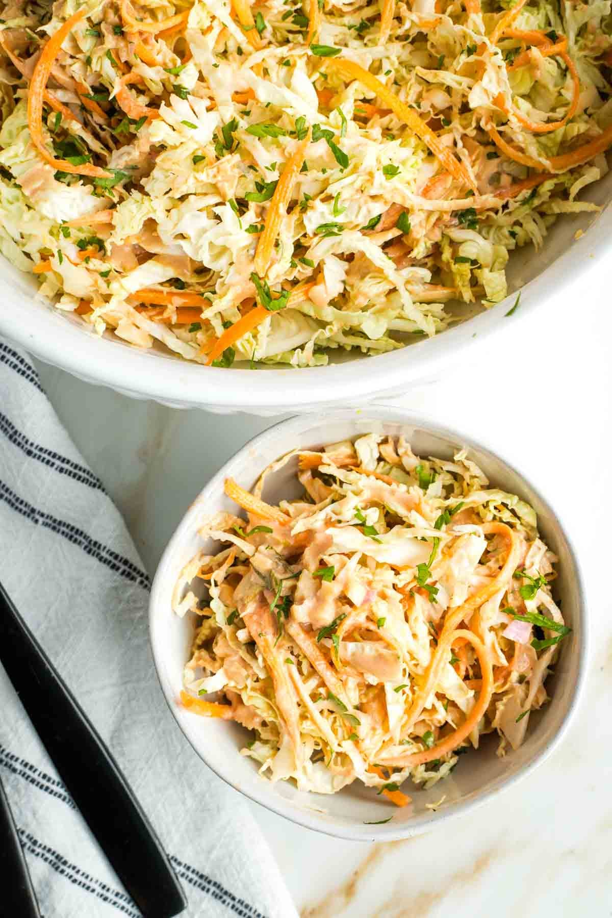 Shredded cabbage and carrots topped with fresh herbs and russian dressing.
