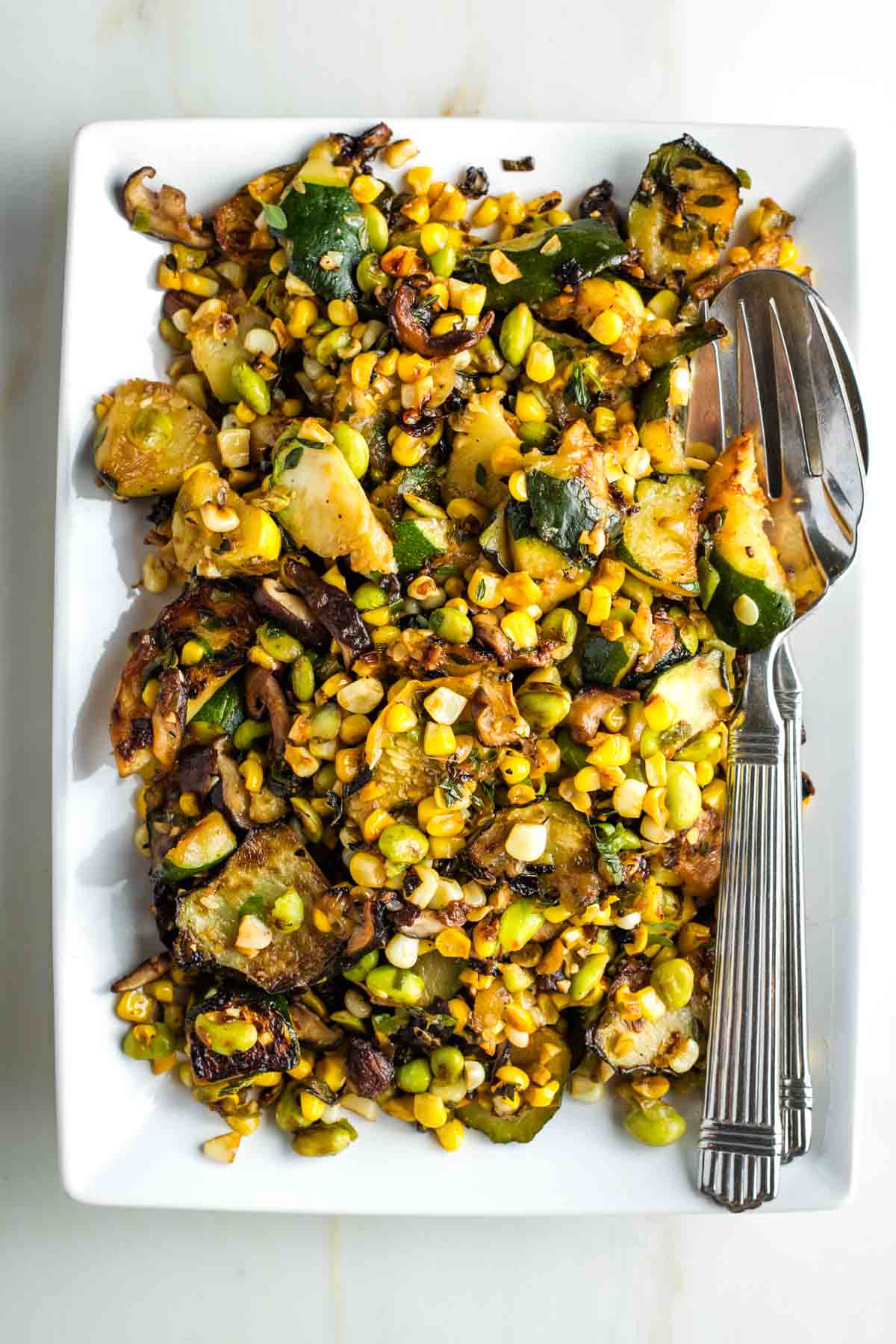 Charred zucchini and mushrooms with corn, onion and edamame. 