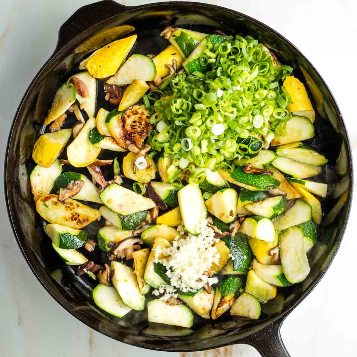 Sliced scallions and minced garlic on top of charred zucchini and mushrooms.