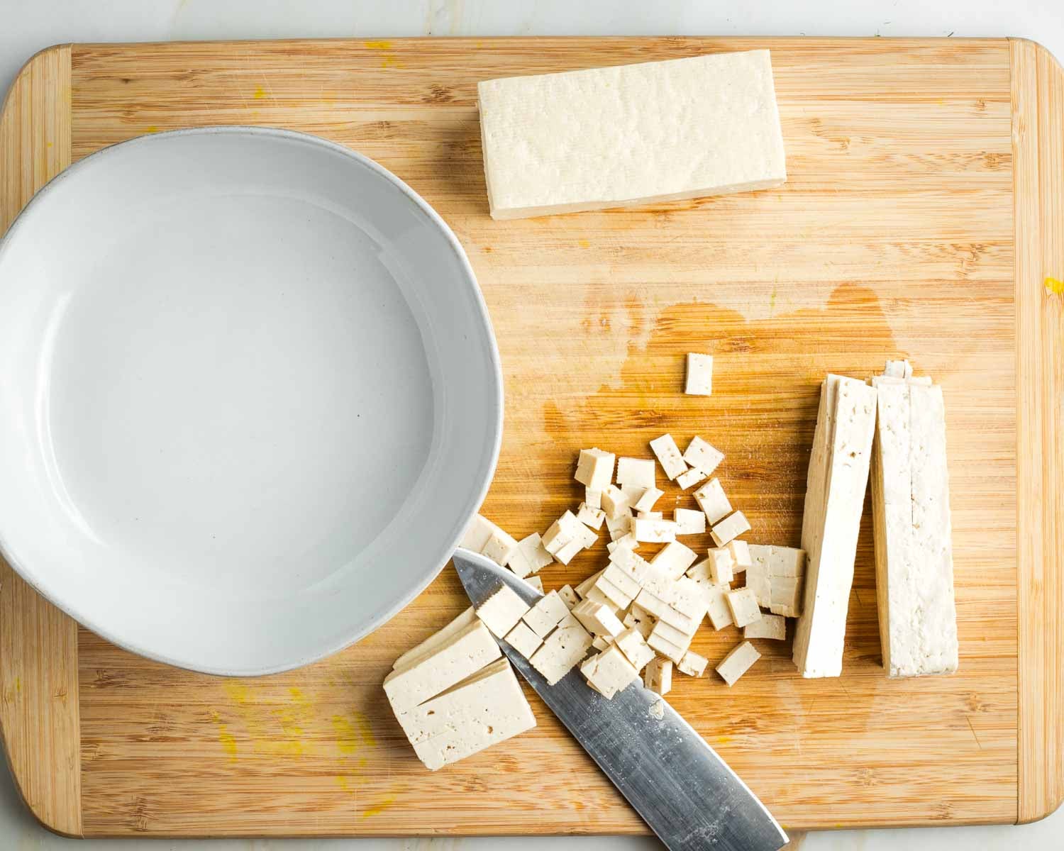 Half a block of tofu cut into slices and then turned on its side to turn those into small diced cubes.