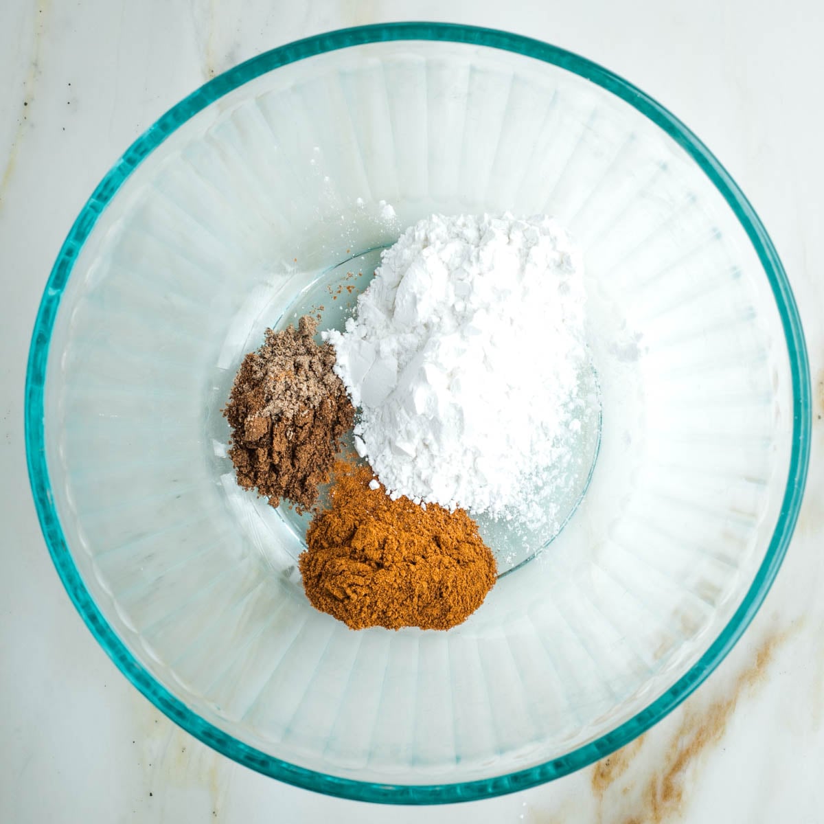 Glass bowl with white arrowroot powder and spices.