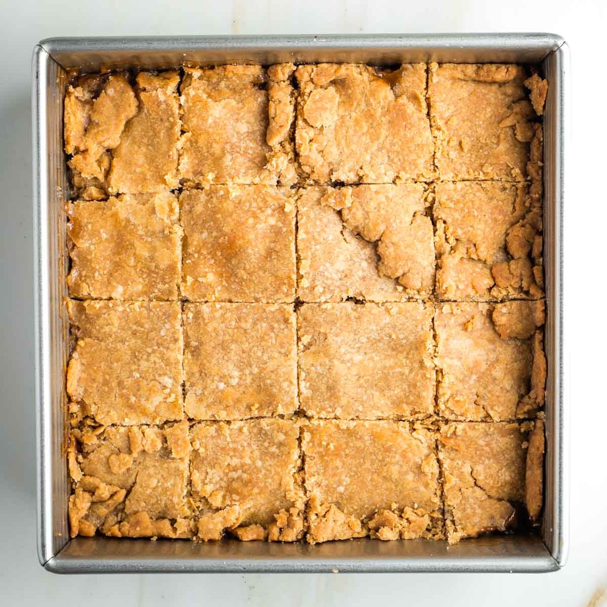 Square pan of pie with top dough, cut into squares.