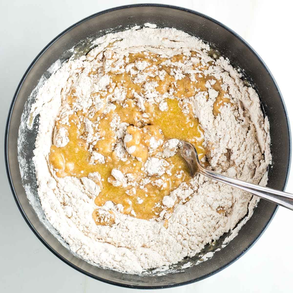 Mixing yellow liquid into a flour mixture.