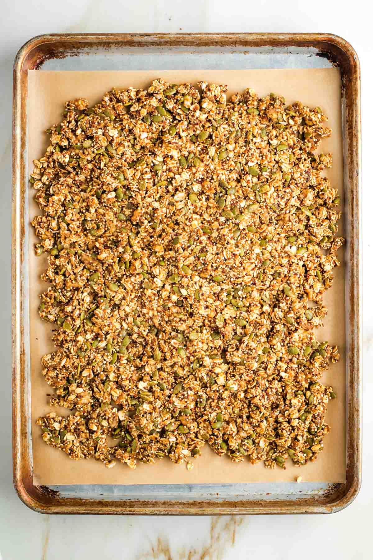 Wet, uncooked granola, spread into a thin layer on a baking sheet.