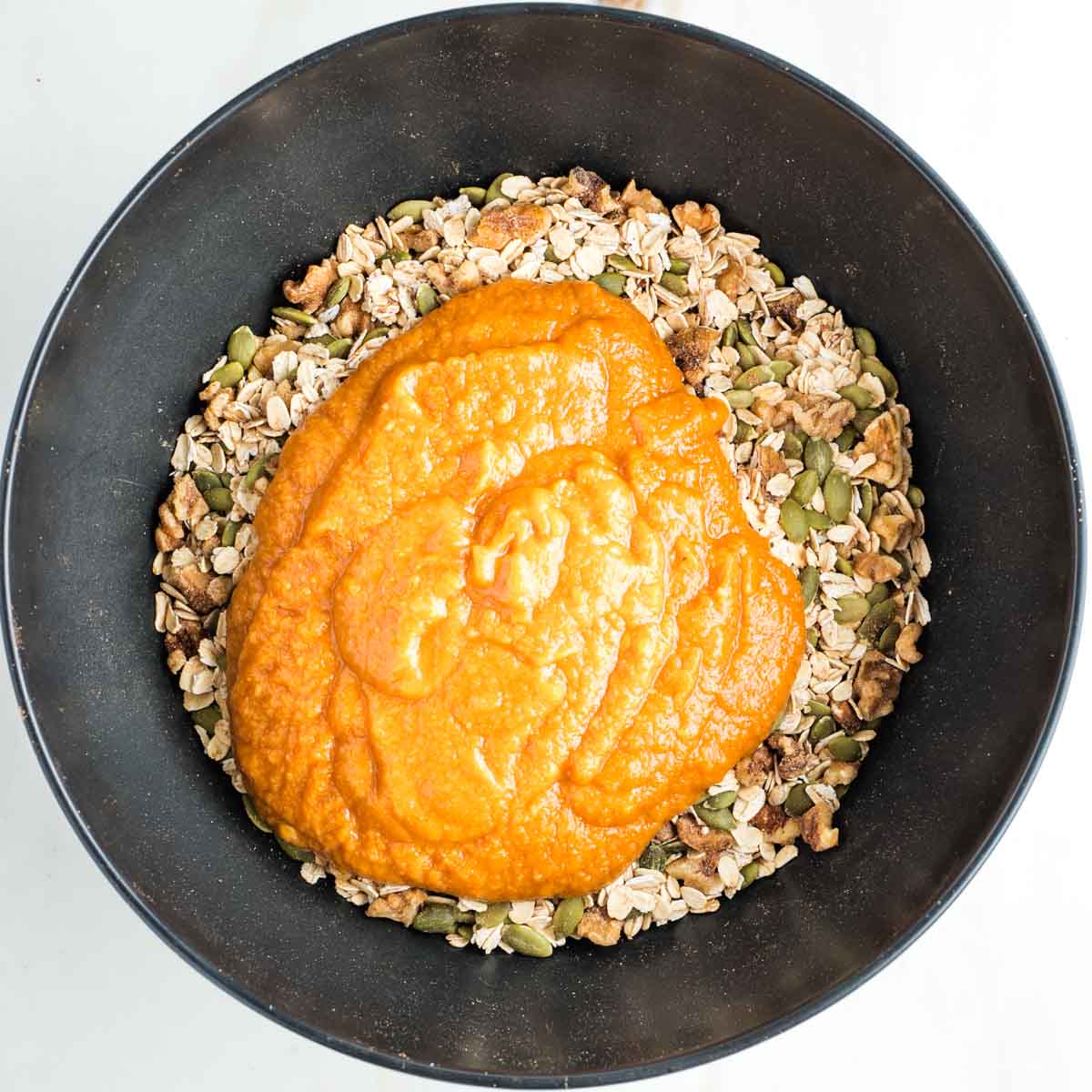 Mixture of nuts, seeds and oats topped with an orange pumpkin mixture.