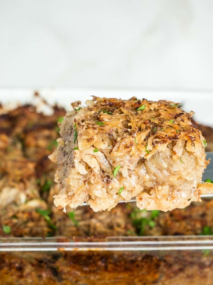 Side view of a piece of vegan potato kugel coming out of the pan.