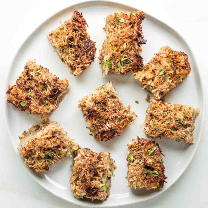 Plate with squares of potato kugel on it.