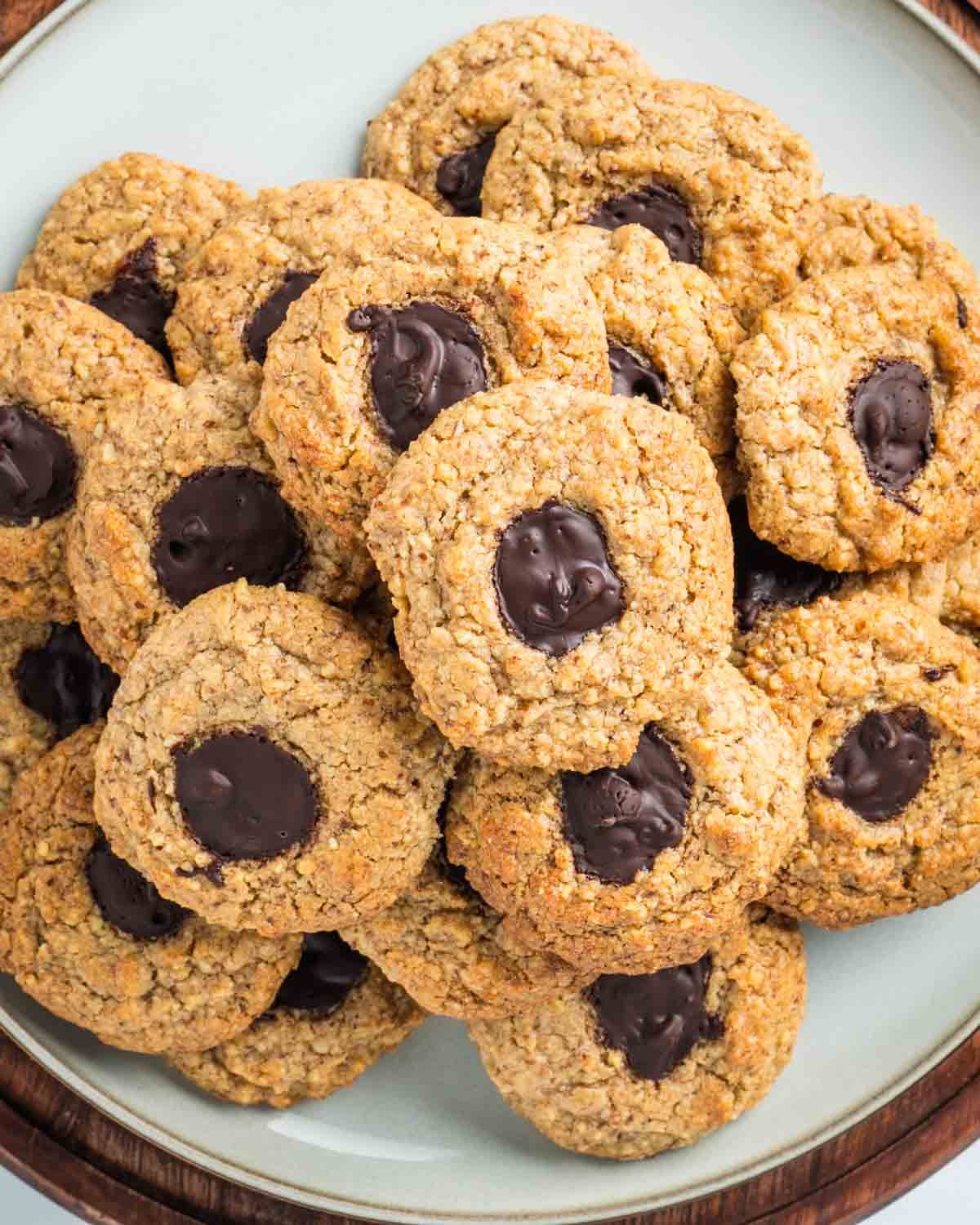 Plate filled with walnut thumbprint cookies filled with chocolate. 