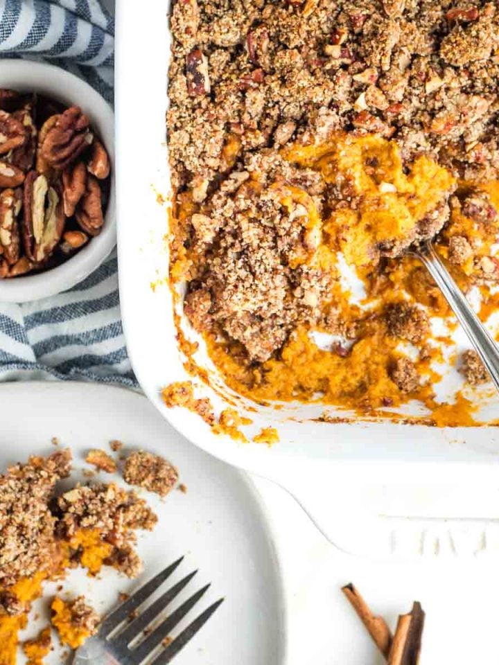 Sweet potato casserole with maple pecan topping, scooped onto a plate.