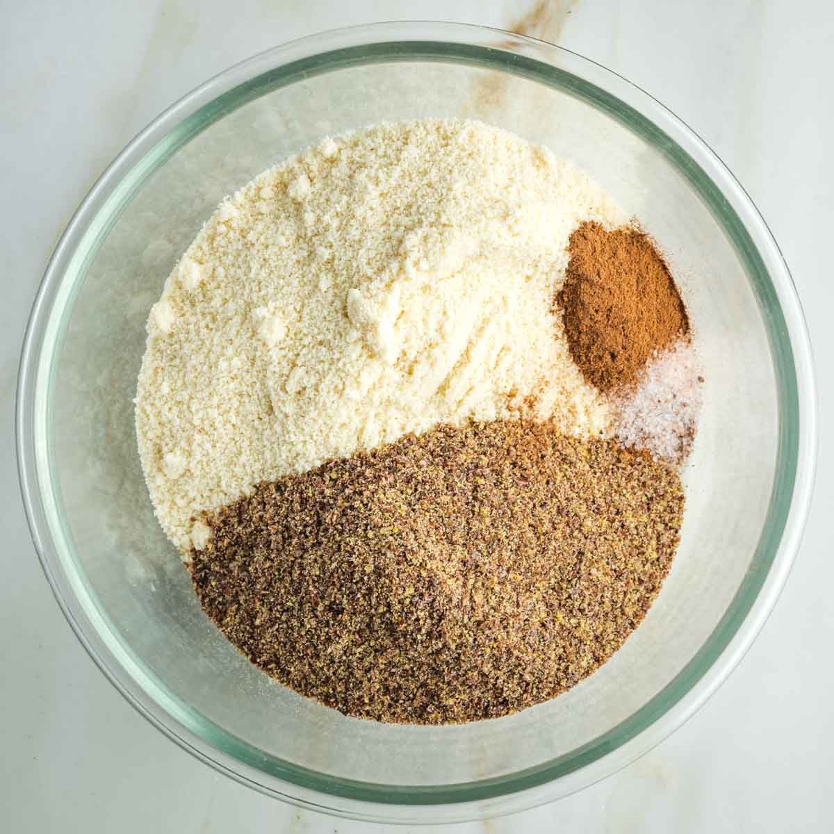 Glass bowl with almond flour, ground flax, cinnamon, allspice and salt. 