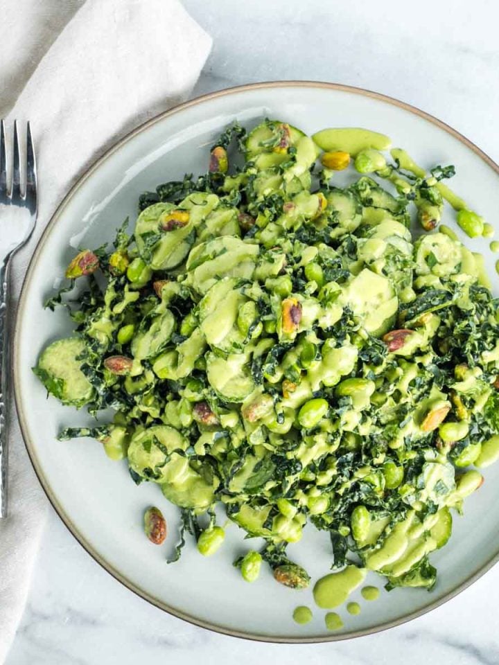 Kale, cucumber, edamame and parsley salad sprinkled with pistachios and drizzled with creamy pistachio dressing.