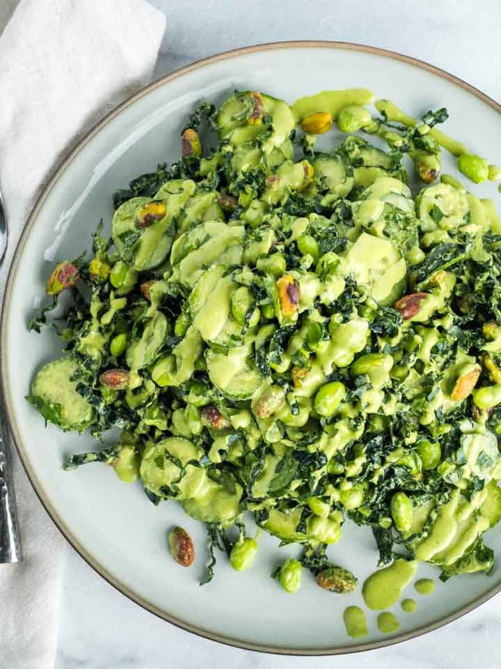 Kale, cucumber, pistachio and edamame salad with creamy light green dressing.