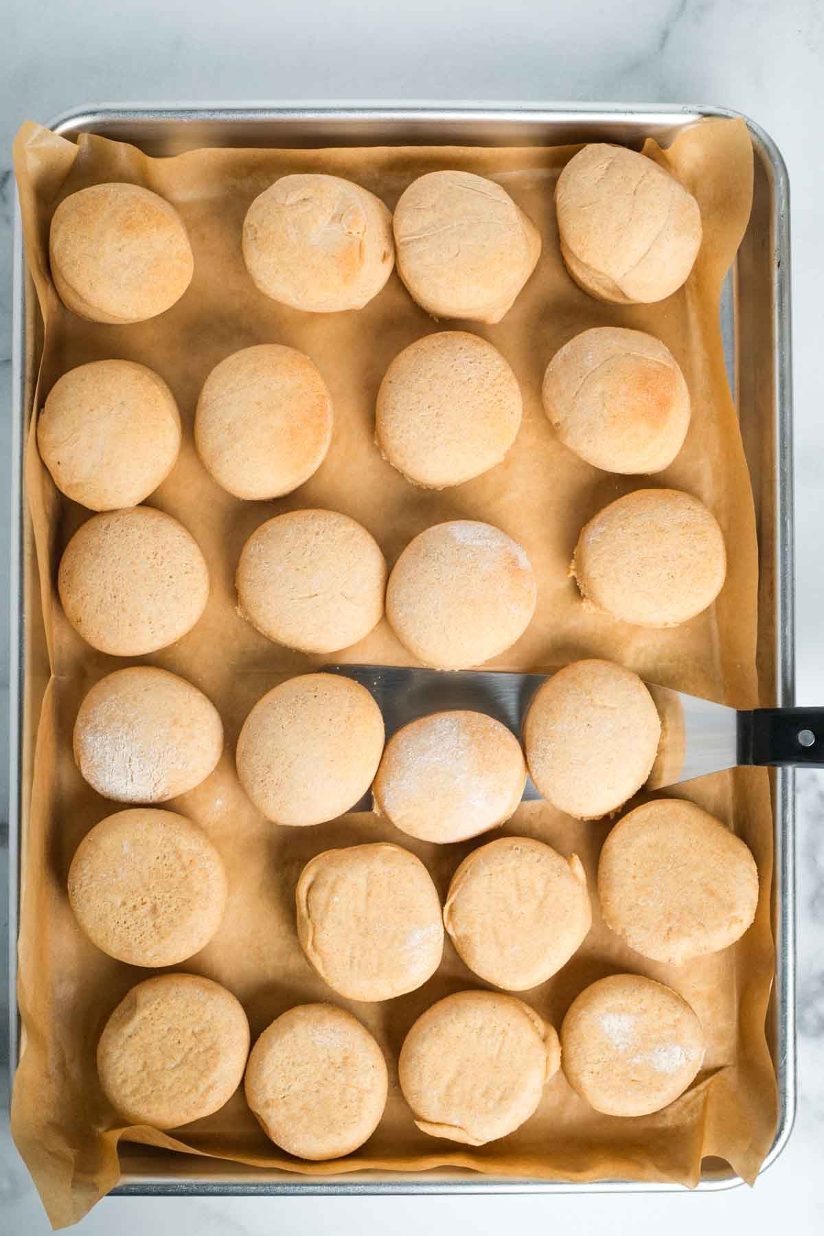 Spatula flipping baked donuts over half way through cooking.