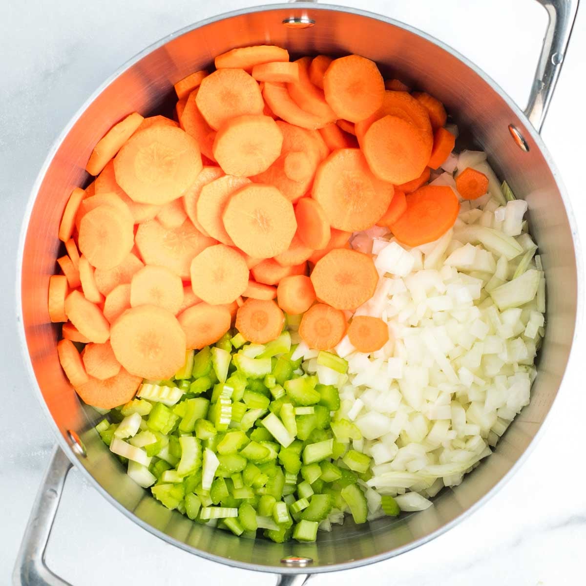 Carrot rounds, diced celery and onions in a soup pot.