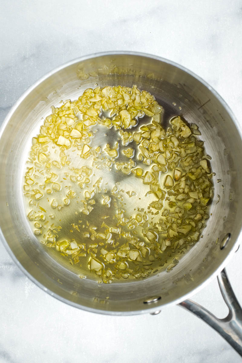 Minced garlic slowly browning in some olive oil in a saucepan.