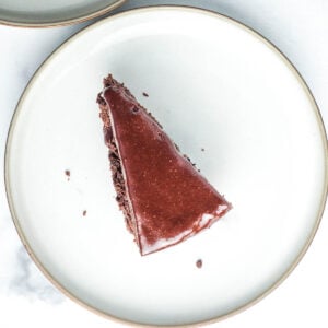 Slice of chocolate cake with chocolate frosting on a white plate.