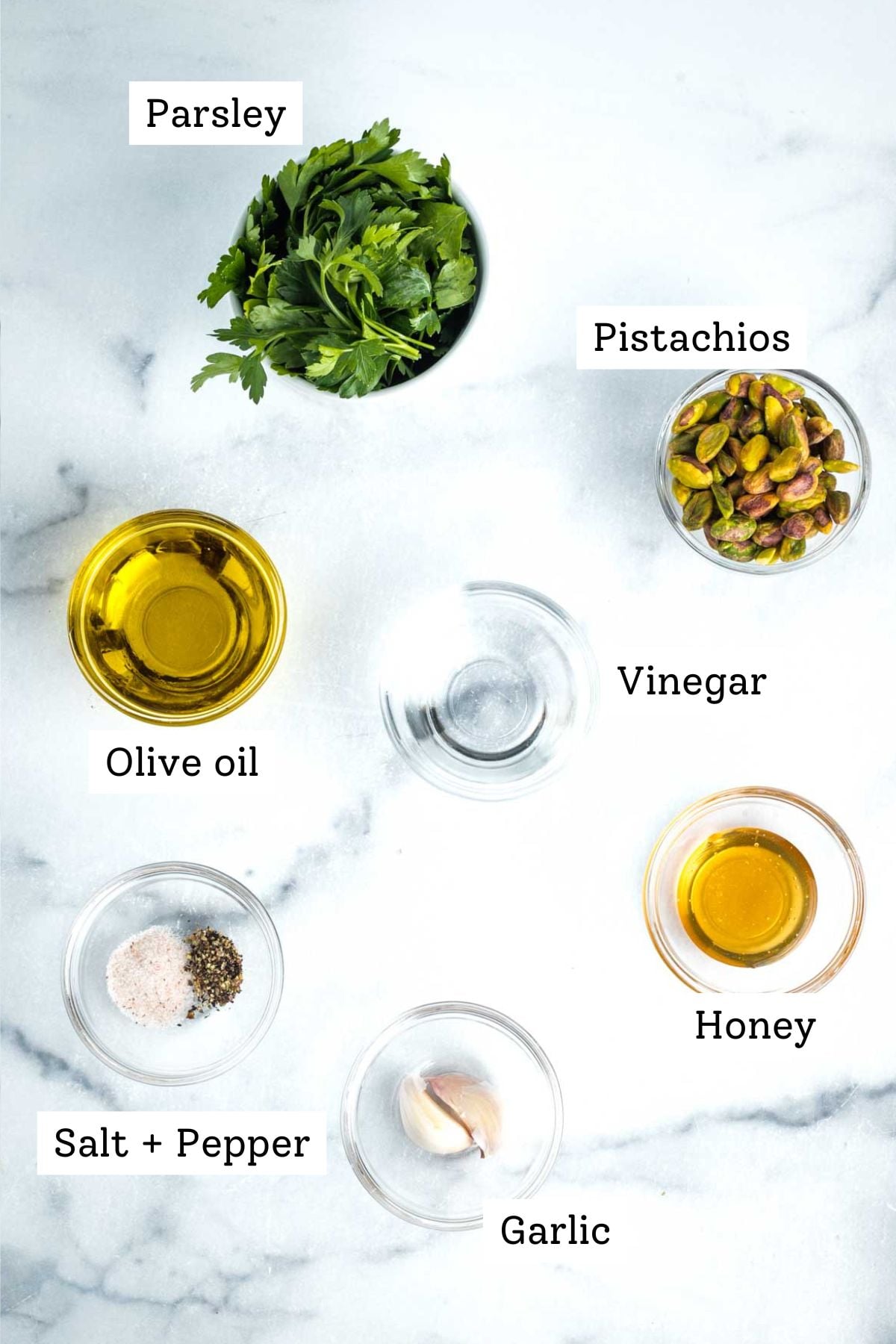 Labeled ingredients: parsley, pistachios, vinegar, olive oil, honey, salt, pepper and garlic cloves.