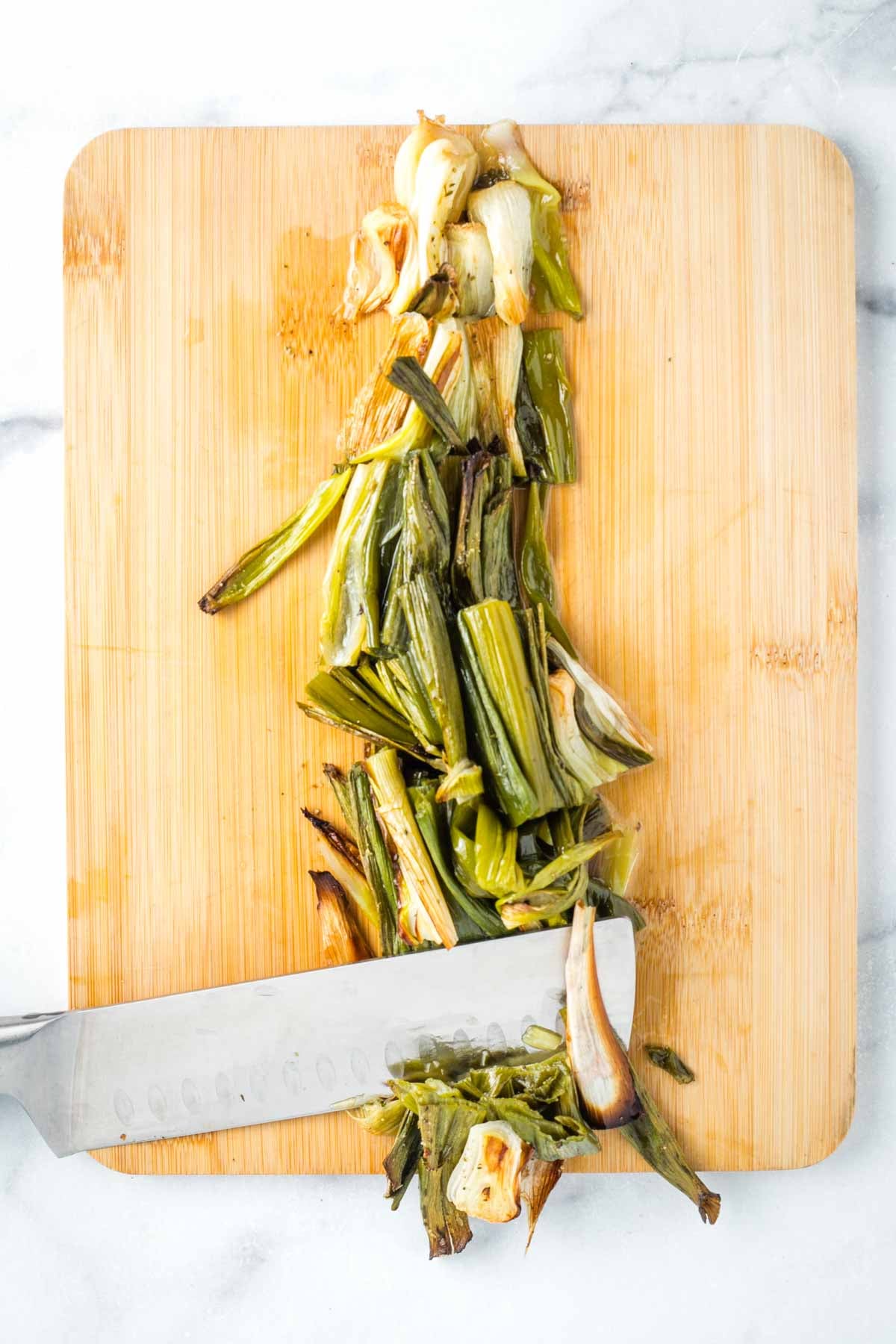 Roughly chopping charred green onions.