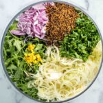 Salad sections with arugula, shaved fennel, thinly sliced onion, crispy quinoa, chopped parsley and lemon zest.