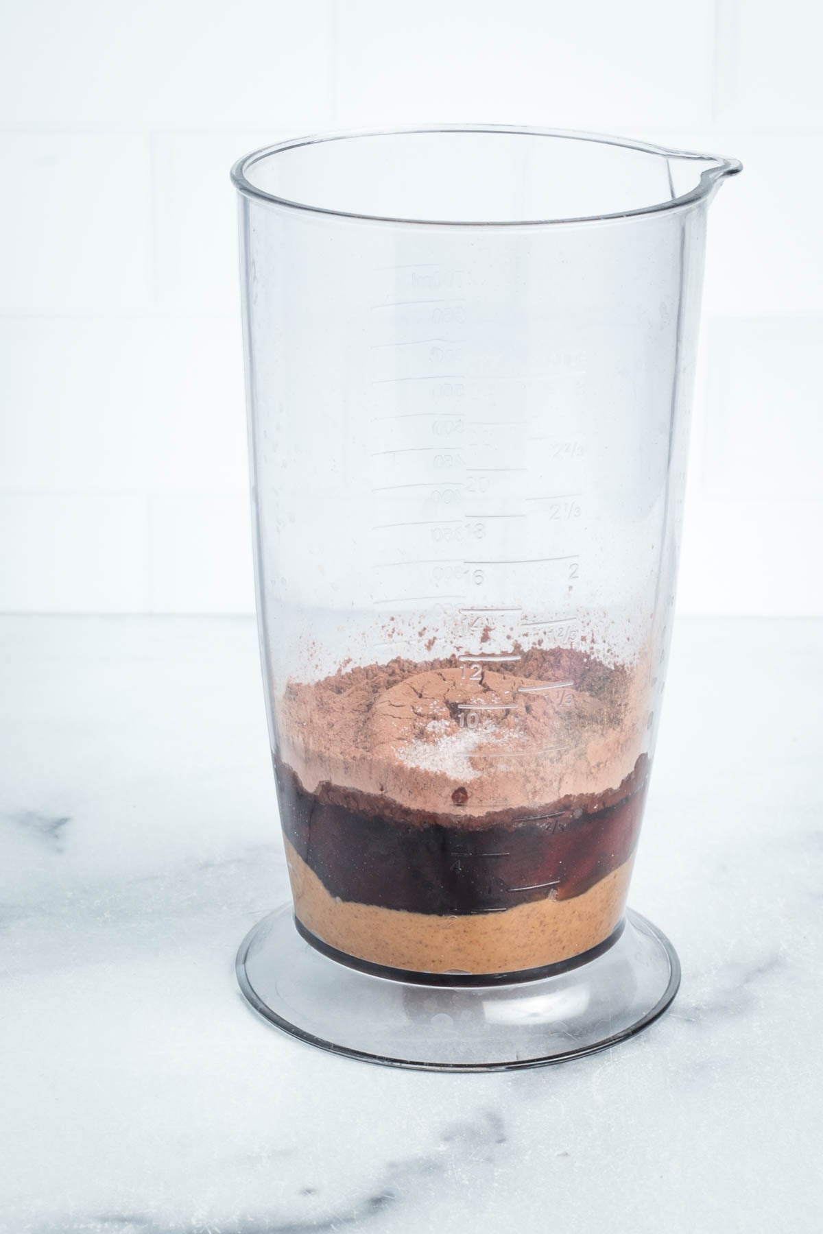 Ingredients for chocolate frosting in a blender cup