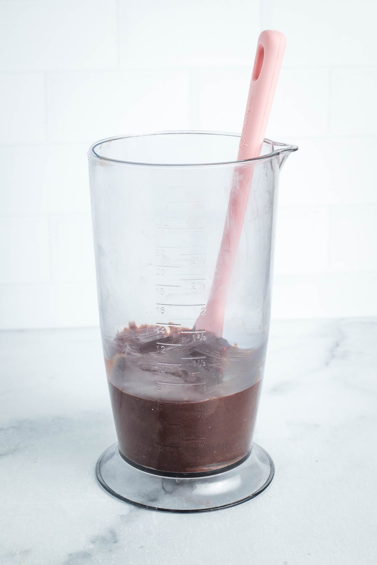 Chocolate frosting in a blender cup.