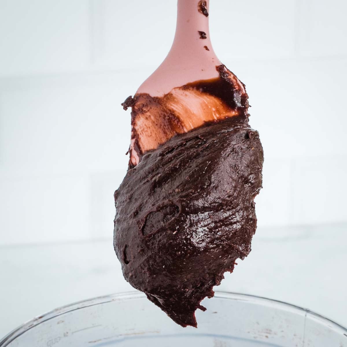 Chocolate frosting holding firm on a pink spatula.