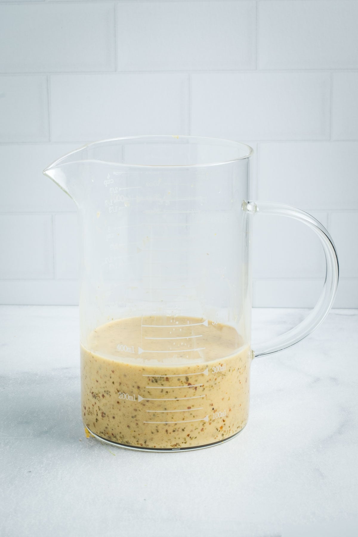 Small glass pitcher with creamy lemon vinaigrette.