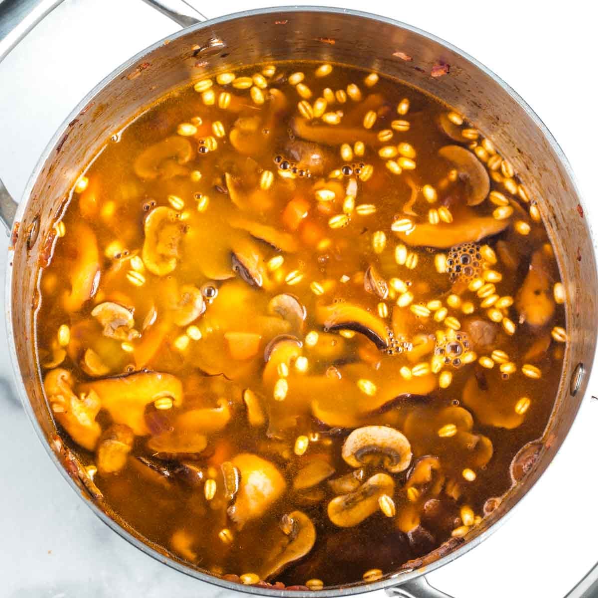 Mushroom barley soup, cooking in a pot. 