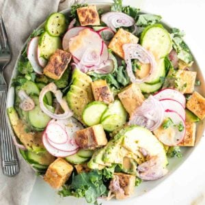 Bed of greens topped with slices of cucumber, shallot, avocado and crisp cubes of tofu drizzled with sesame ginger dressing.