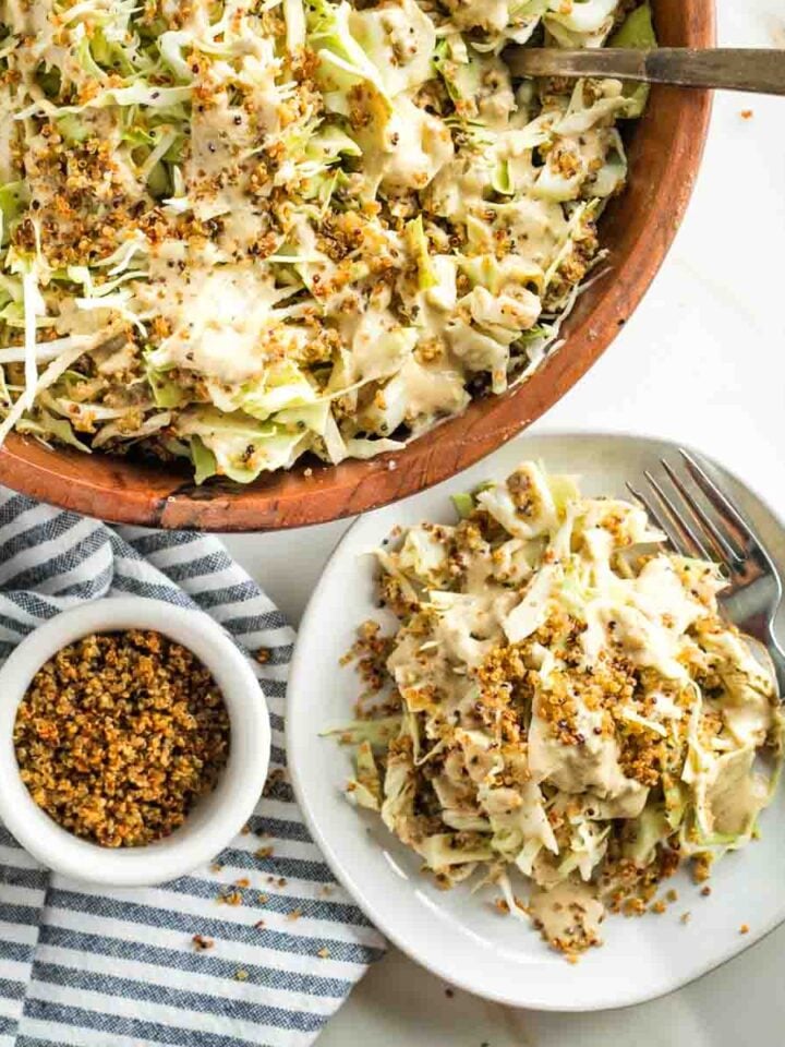 Cabbage with caesar dressing and crispy quinoa in a serving bowl and on a plate.