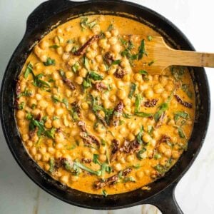 SKillet with creamy tomato sauce, chickpeas, sun dried tomatoes and fresh basil.