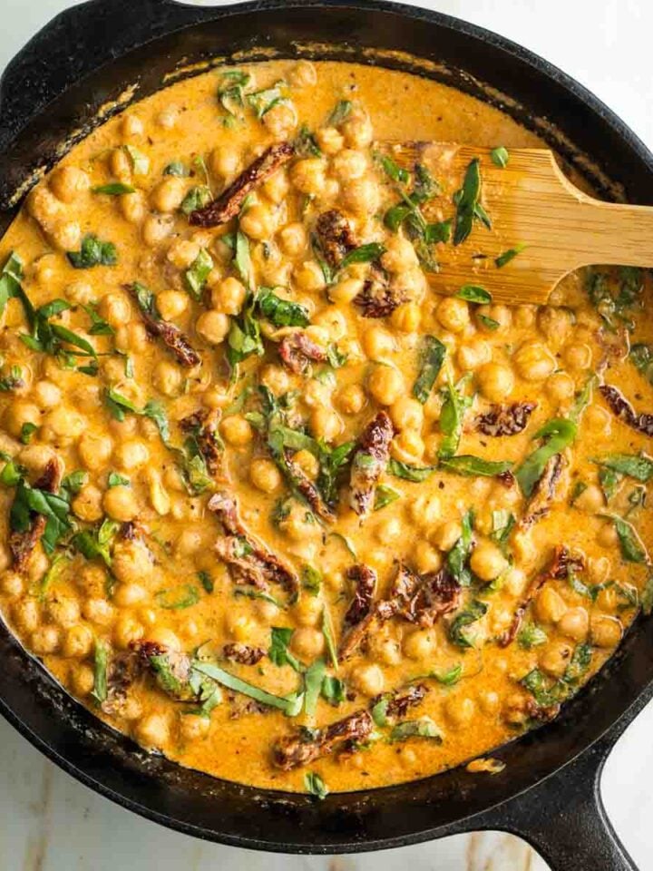 SKillet with creamy tomato sauce, chickpeas, sun dried tomatoes and fresh basil.