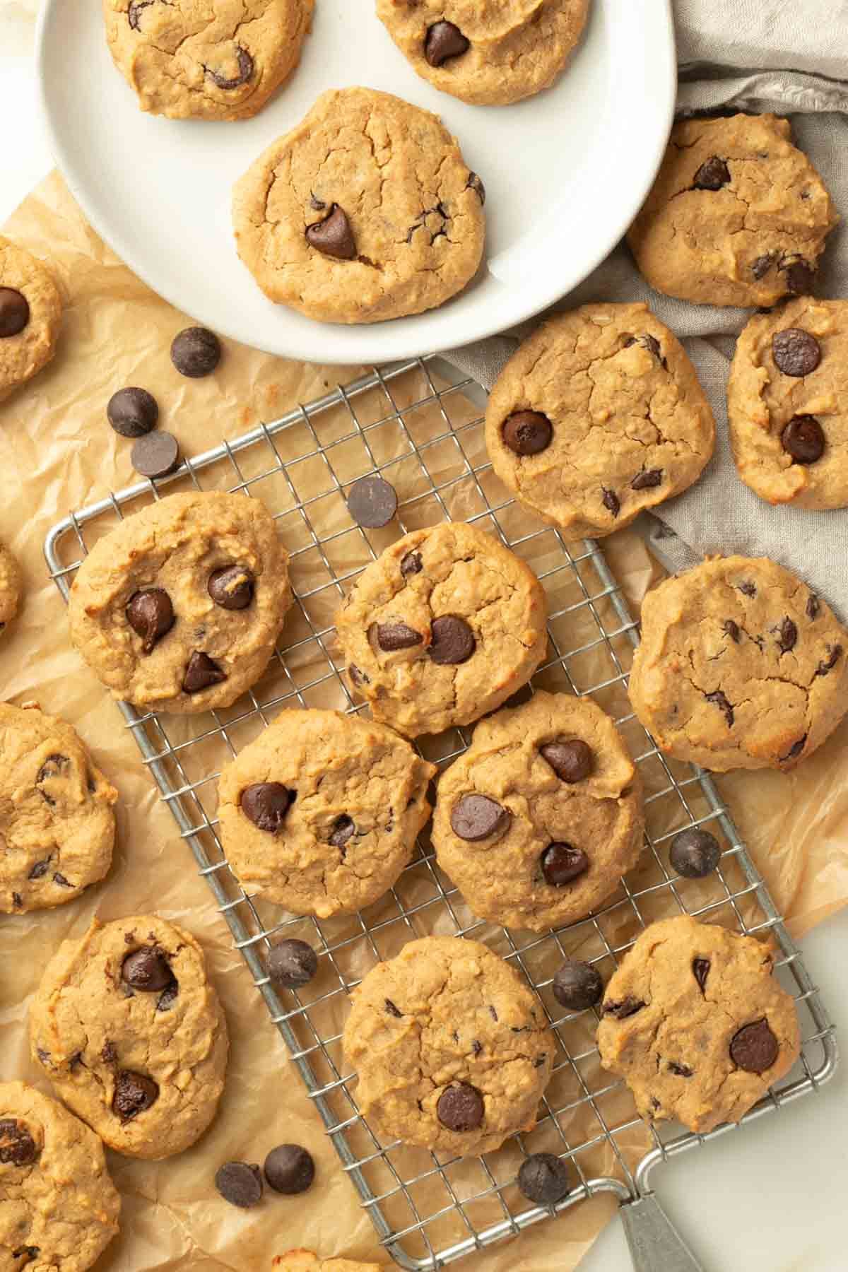 Chocolate Chip Cookies on a plate, on a rack and on parchment paper.