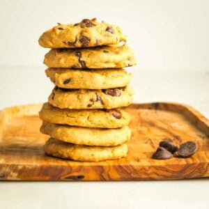 Stack of chocolate chip cookies on a wooden board.