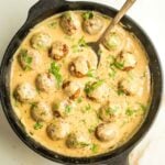 Cast iron pan filled with vegan Swedish meatballs in a creamy sauce.