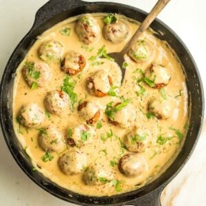 Cast iron pan filled with vegan Swedish meatballs in a creamy sauce.