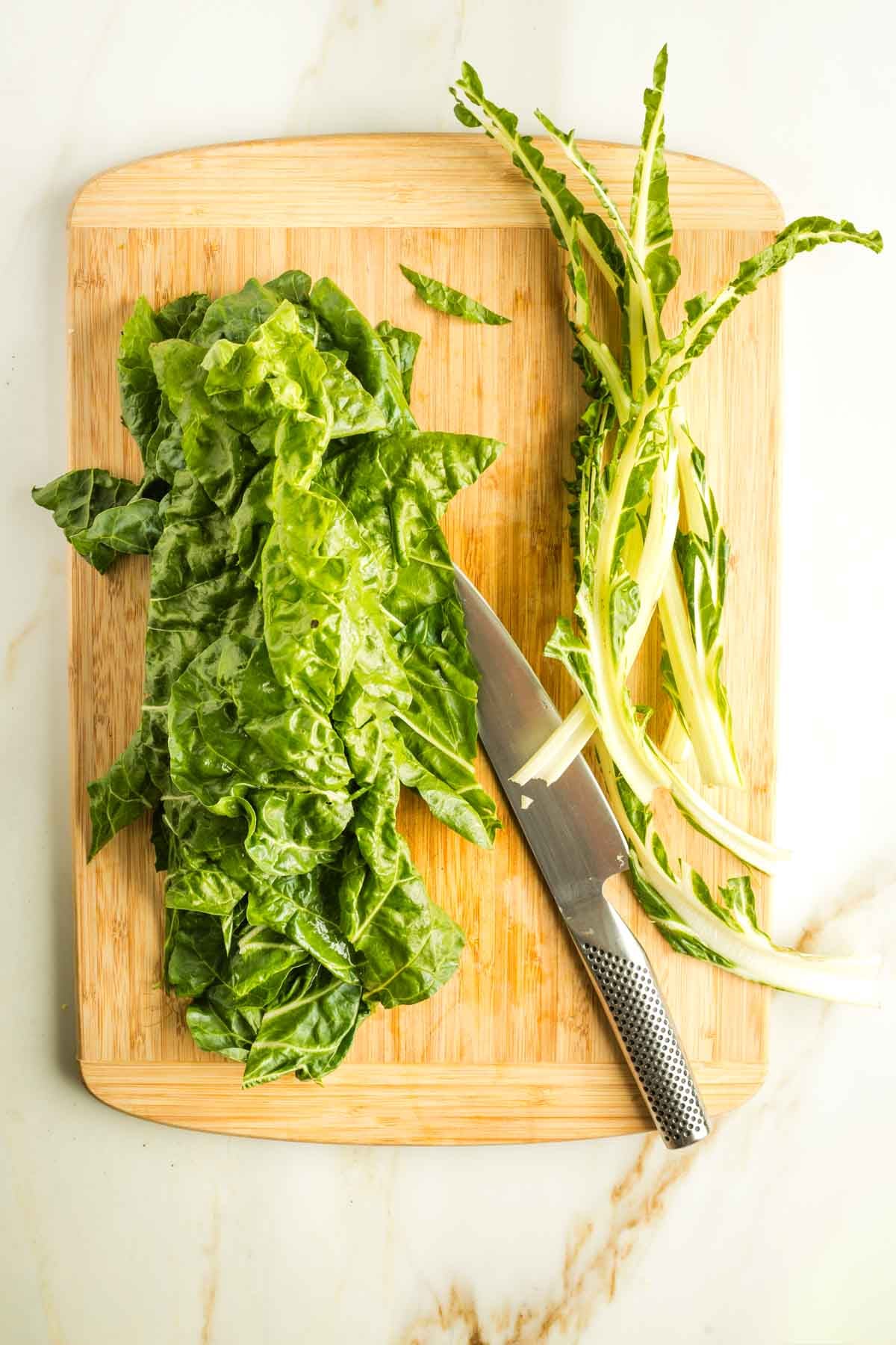 Leaves separated from stems on green chard. 
