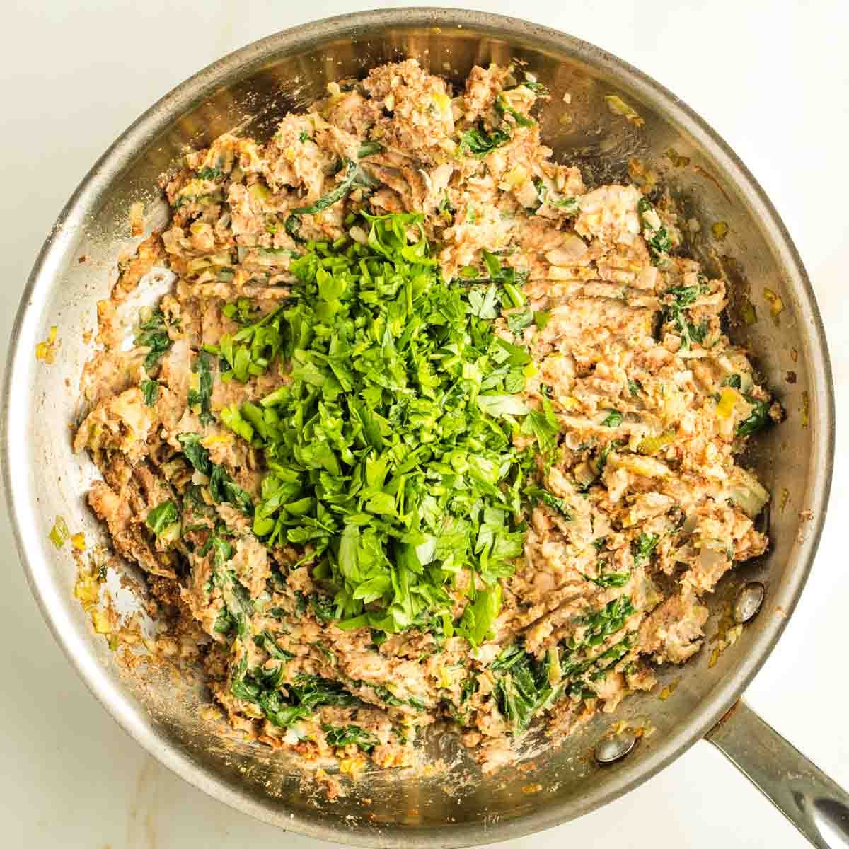 Chopped parsley on top of a bean/leek mixture.
