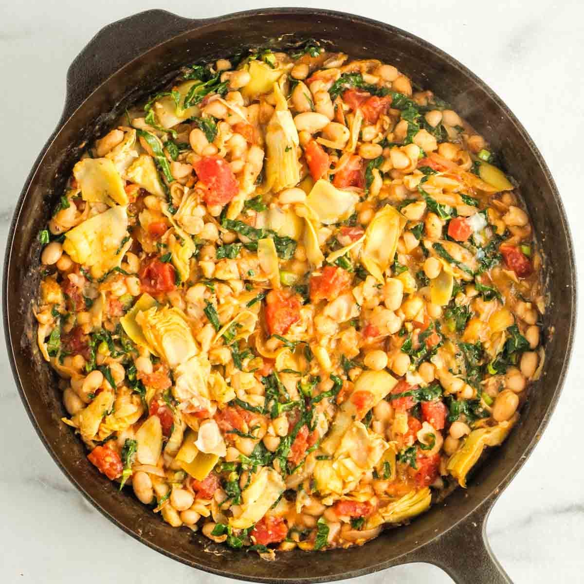 Tuscan white bean skillet with kale, tomatoes, onions and artichoke hearts.